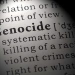 Close-up of the word 'Genocide' in a dictionary with its definition