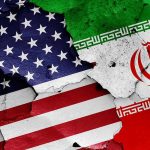 Iran President DECLARES War Against America Cracked American and Iranian flags on a wall.