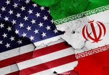 Iran President DECLARES War Against America Cracked American and Iranian flags on a wall.