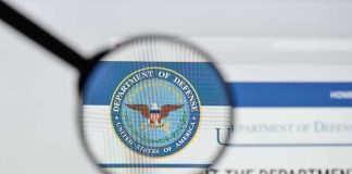 Magnifying glass over Department of Defense logo.