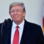 Trump’s BIZARRE Choice Stuns Visa Officials Man in suit and tie speaking at podium.