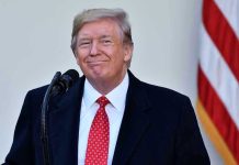 Trump’s BIZARRE Choice Stuns Visa Officials Man in suit and tie speaking at podium.