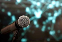 Music Icon Announces Shock Cancer Diagnosis Microphone with abstract, blurred blue background.