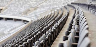 Empty rows of gray seats in a stadium.