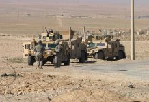 Trump MILITARIZES Border – Sets Up Command Post! Soldiers standing near armored vehicles in desert terrain.