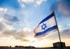 Eurovision Boycott ERUPTS – Major Countries PULL OUT! Israeli flag waving against a sunset backdrop with clouds
