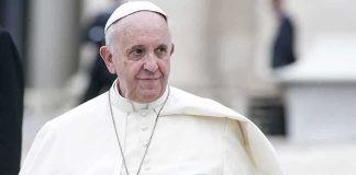 Pope Francis smiling while wearing white robes in an outdoor setting