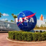 Fifty-Year Moon Drought Ends – We’re Going Back! NASA logo sculpture with spaceship and palm trees.