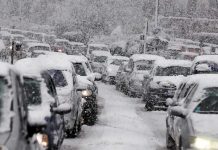DEVASTATING Storm Plunges U.S. – 10,000 Flights CANCELLED! Traffic jam with cars covered in heavy snow during a snowstorm