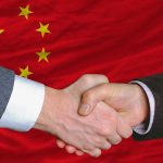 Canada Bows to Beijing – Publicly Declares New World Order Two hands shaking in front of the Chinese flag
