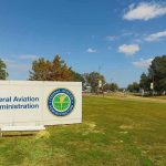Federal Aviation Administration sign on grassy lawn.