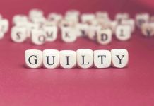 Dice spelling GUILTY on a red surface.