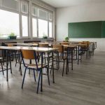Teachers Union DEMANDED Children Protest ICE Empty classroom with desks, chairs, windows, and chalkboard.