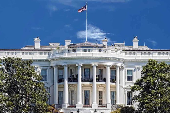 The White House with the American flag flying against a blue sky