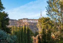 Hollywood Star ARRESTED After Drunken Assault! Hollywood sign on hill surrounded by trees and buildings.
