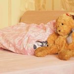 Father CONFESSES Abusing Infant — 30 Broken Bones! A cozy bedroom scene featuring a stuffed bunny and pink bedding