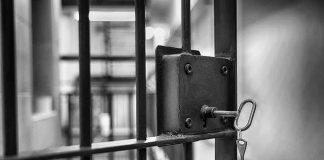 Trans Inmate Transferred After Impregnating Too Many Woman Jail cell door with key in lock.
