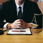 Person in suit with gavel and scales of justice