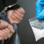 Fentanyl Drug Crisis: 100 Million Lives at Stake Person handcuffed, police holding bag of white substance.