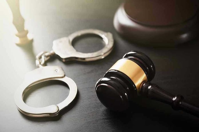 Handcuffs and judges gavel on the table.