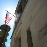 Washington Targets Brazil’s Top Crime Syndicates American flag at Department of Justice building exterior.