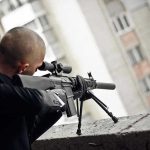 MOTHER HIRED HITMAN—Hours Before Custody Hearing Person aiming a rifle from a building balcony.