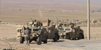Powerful U.S.-Nigeria Strike Under Scrutiny Soldiers standing near armored vehicles in desert terrain.