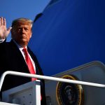 Trump’s Surprise Call to Nvidia CEO Sparks Tensions A political figure waving while standing on the steps of an aircraft