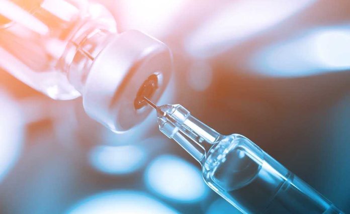 Close-up of a syringe drawing liquid from a vial