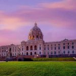 Historic building with dome under a pinkish-purple sky.