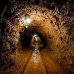 Border Tunnel Stuns: Fake Store, Real Disaster Dimly lit underground tunnel with rail tracks and rocky walls