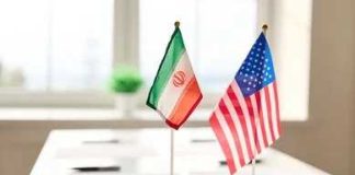 Mini flags of Iran and the United States on a conference table