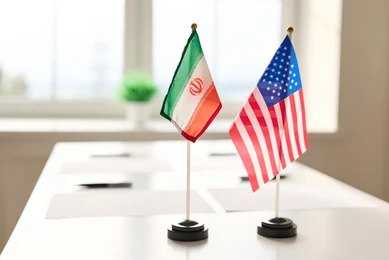 Mini flags of Iran and the United States on a conference table