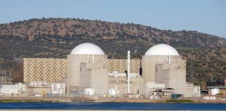 Stocks Soar on Iran Ceasefire, But the War May Not Be Over Nuclear power plant with domed structures beside a water body and mountains in the background