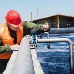A New Kind of Battlefield Emerges. Worker inspecting water treatment plant pipes.
