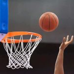 Clark Controversy Puts WNBA Under Fire Basketball nearing hoop with player’s hand reaching up