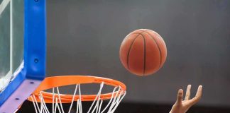 Clark Controversy Puts WNBA Under Fire Basketball nearing hoop with player’s hand reaching up