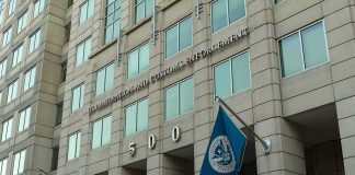 Unmarked Vehicles: Deadly ICE Stop Faces Scrutiny U.S. government building facade with American and blue departmental flags