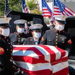 U.S. Marines carry a flag-draped casket into a hearse