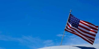 Another U.S. Troop Killed as America’s Iran War Enters American flag on U.S. Air Force aircraft against blue sky