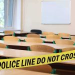 Empty classroom with police tape across desks
