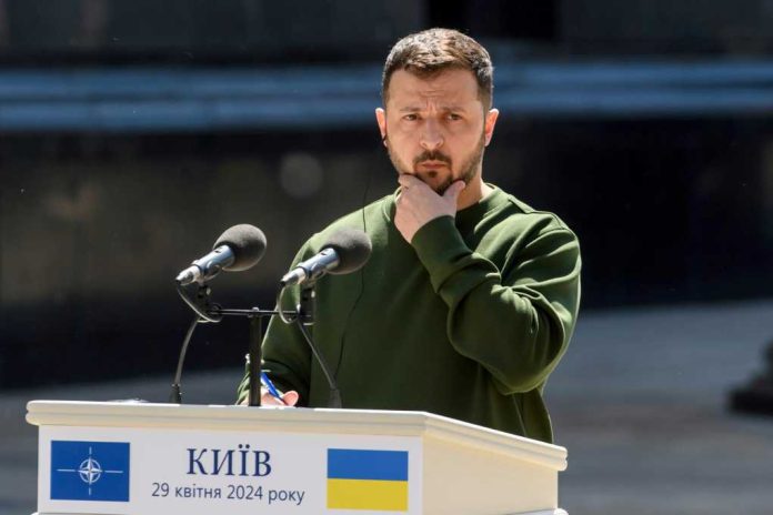 shutterstock_2459446777 A public figure in a green sweater pondering during a speech at a podium in Kyiv
