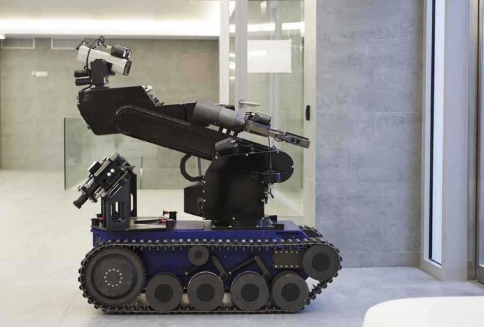 shutterstock_68039032 A robotic arm mounted on a tracked base in a modern workspace