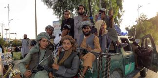 Safer Streets, Darker Future? Armed men sitting on a pickup truck.