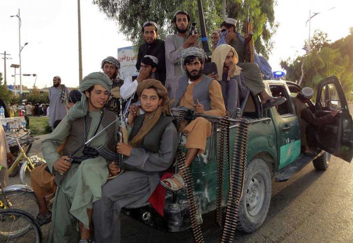 2026737029 Armed men sitting on a pickup truck.