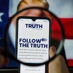 Trump’s Latest AI Spree Has Everyone Talking Phone screen displaying Truth Social app magnified