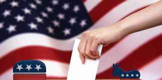 Hand casting ballot between Republican elephant and Democratic donkey