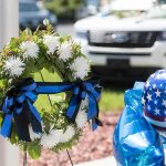 Mother of Three. Young NYPD Officer Dies After Cosmetic Surgery Memorial wreath with white flowers and blue-black ribbons beside star-spangled balloons