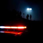Pentagon Probes Alleged UFO Video Cover-Up Police car lights at night with silhouettes in the distance