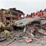Deadly Quake Leaves Colombia in Ruins Rescue workers in orange uniforms on a collapsed building site after an earthquake